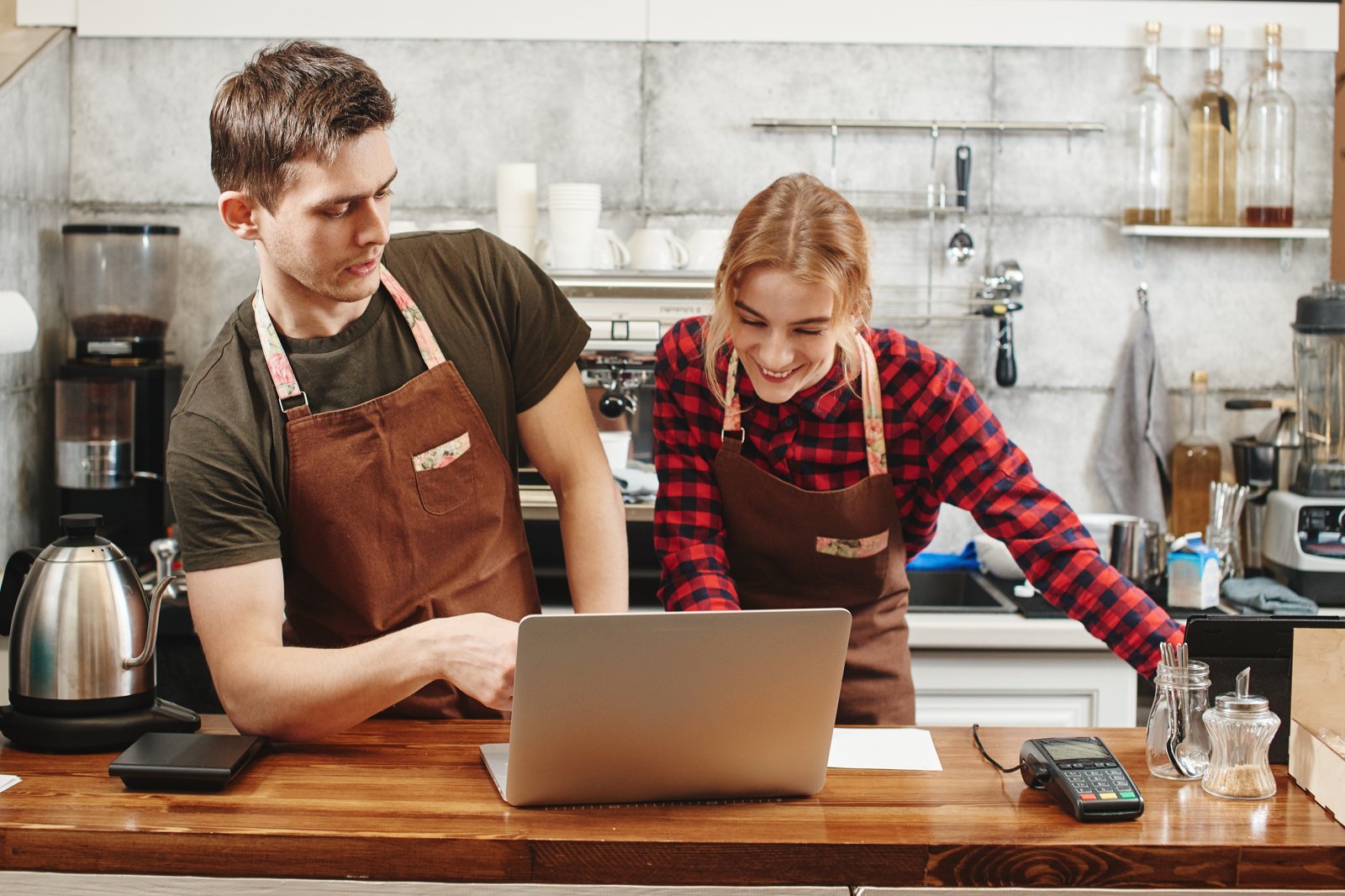 Two café team members reviewing the business on a laptop
